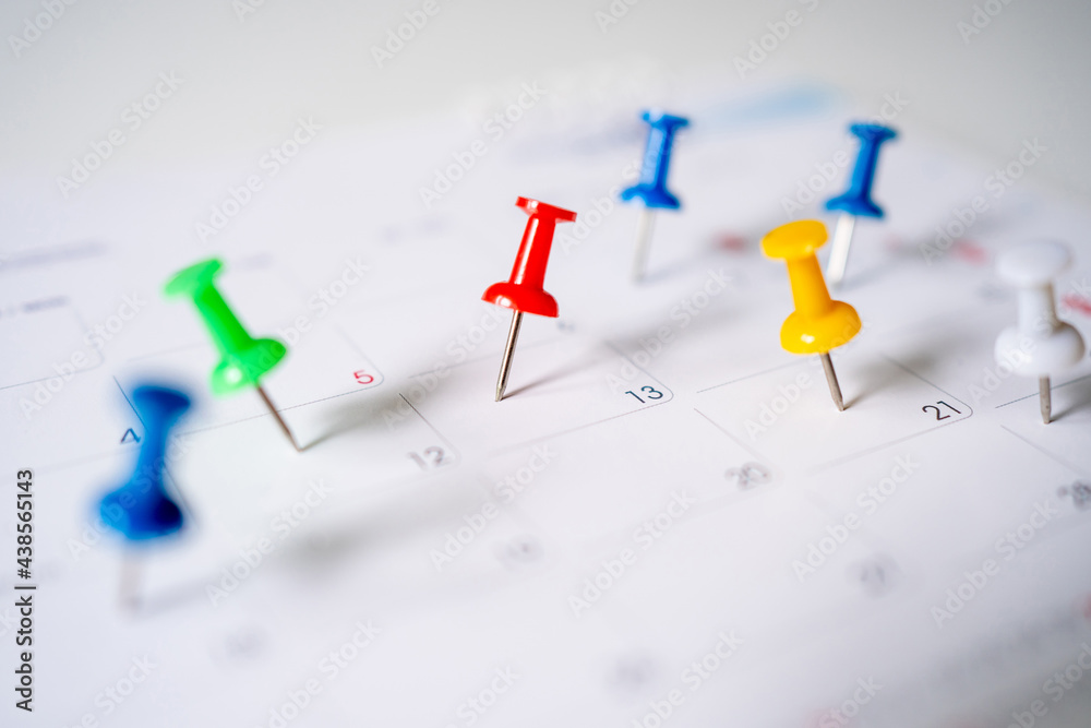 Push pins on calendar, mark the Event day with a red pin. Close-up of red pins. Push pins on calendar, mark the Event day with a red pin. Close-up of red pins.