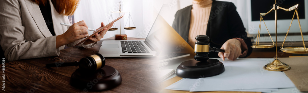 Justice and law concept.Male judge in a courtroom with the gavel, working with, computer and docking keyboard, eyeglasses, on table in morning light Justice and law concept.Male judge in a courtroom with the gavel, working with, computer and docking keyboard, eyeglasses, on table in morning light