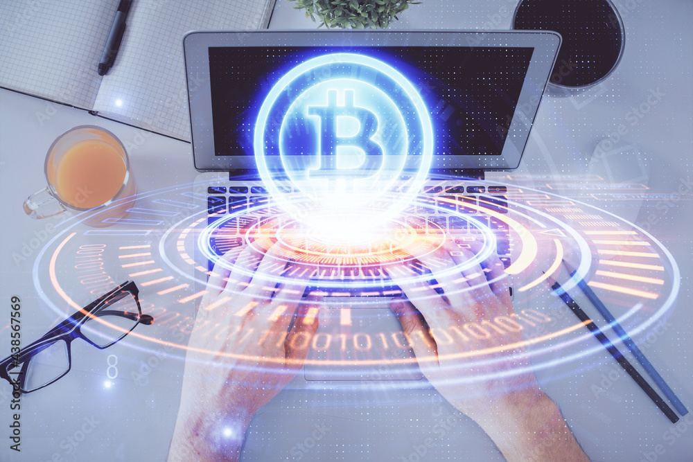 Double exposure of man's hands typing over computer keyboard and crypto currency theme hologram drawing. Top view. Blockchain concept.