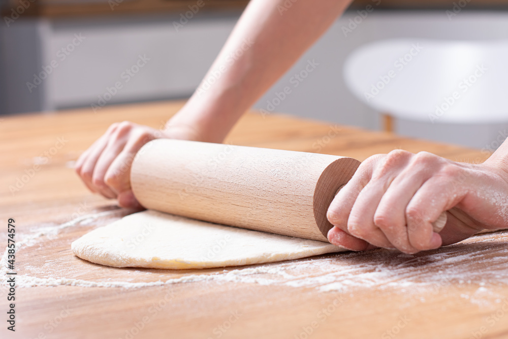 Rolling pin and dough. Woman preparing dough Rolling pin and dough. Woman preparing dough