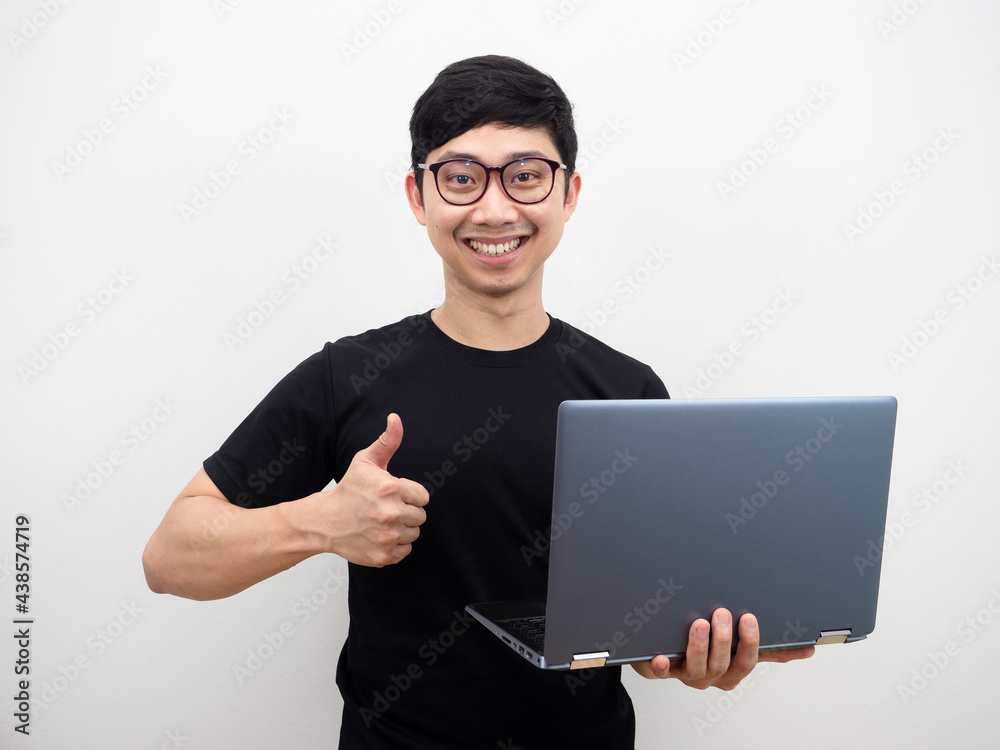 Asian man with glasses holding laptop thumb up and happy smile face on white background Asian man with glasses holding laptop thumb up and happy smile face on white background