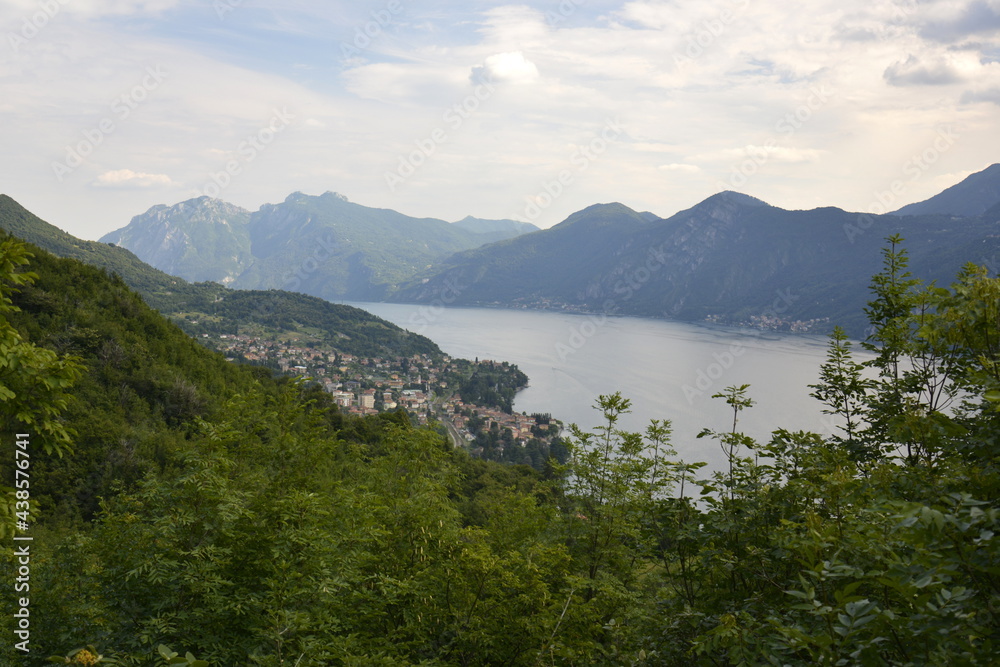 Panorama of mountain lake Como surrounded by green hills covered with cedar forest