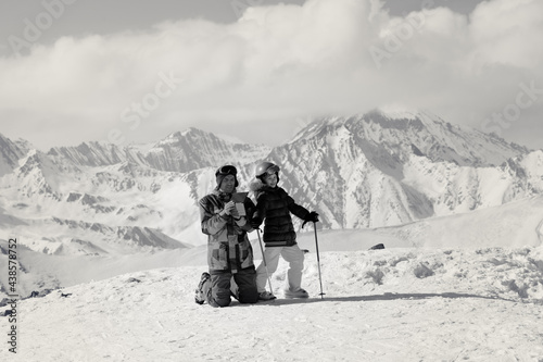 Little skier and her father on top of snowy ski slope