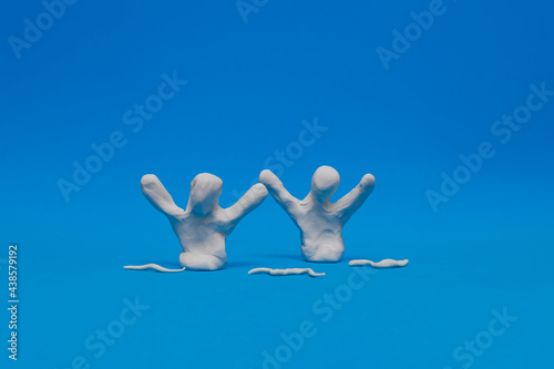Two white modeling clay dummies practicing synchronized swimming