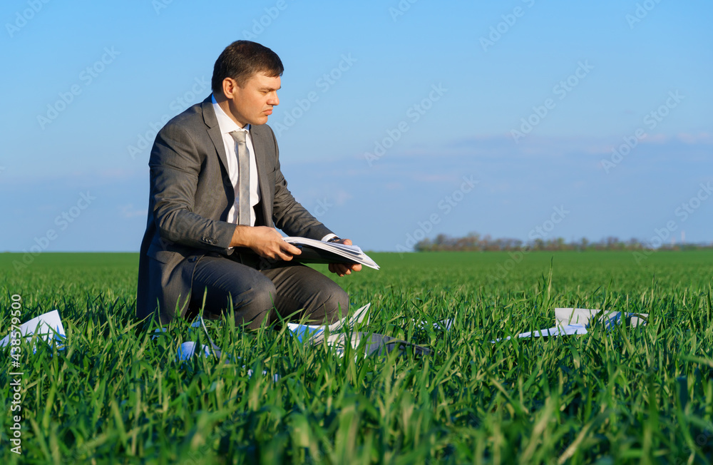 businessman works in a green field, freelance and business concept, green grass and blue sky as background