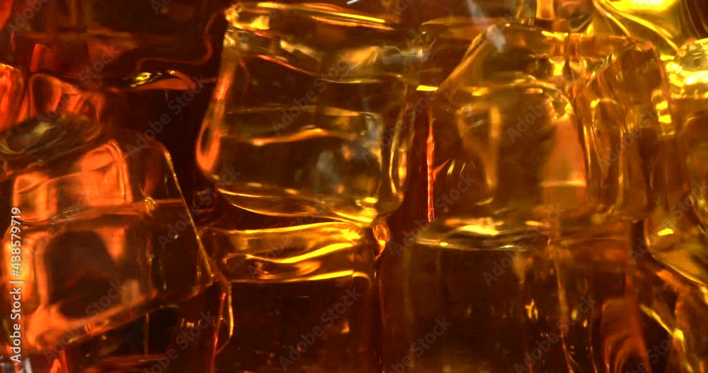 Alcohol concept. Super macro shot of pouring the whiskey to the glass. Many ice in glass. Alcohol concept. Super macro shot of pouring the whiskey to the glass. Many ice in glass.