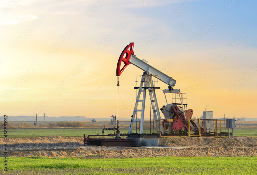 Crude oil pump jack at oilfield on sunset backround. Fossil crude output and fuels oil production. Oil drill rig. Crude mining concept. Oil prices on the trading exchange. Crude oil pump jack at oilfield on sunset backround. Fossil crude output and fuels oil production. Oil drill rig. Crude mining concept. Oil prices on the trading exchange.