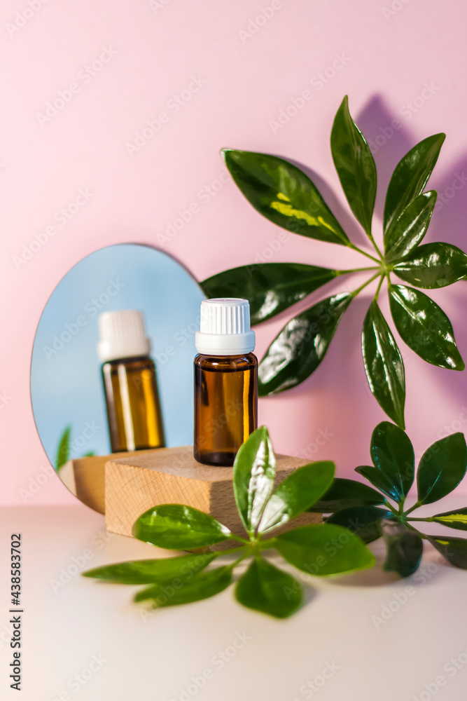 The mirror reflects a brown glass bottle with an eyedropper on a beige-pink background. Organic natural essential oil for aromatherapy. The mirror reflects a brown glass bottle with an eyedropper on a beige-pink background. Organic natural essential oil for aromatherapy.