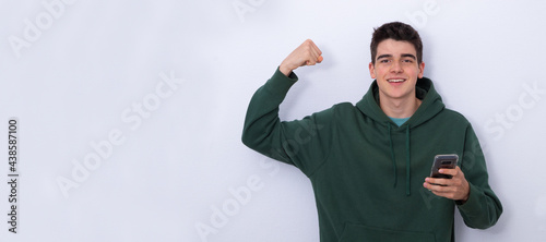 Foto happy teenage student isolated with cell phone euphoric with success