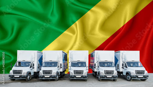 Congo flag in the background. Five new white trucks are parked in the parking lot. Truck, transport, freight transport. Freight and logistics concept photo