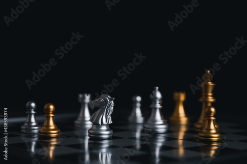 Gold king winner surrounded with silver chess pieces on chess board game competition.concept strategy  leadership and success business.