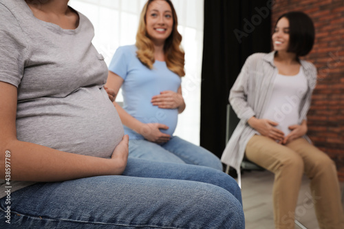Group of pregnant women at courses for expectant mothers indoors, closeup photo