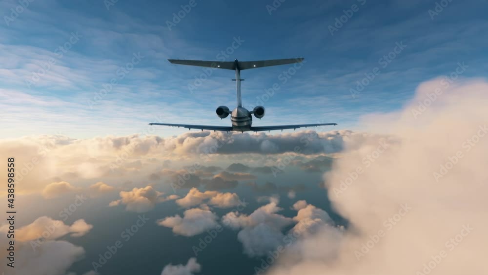 Rear view of a private airplane flying over clouds: Aerial view of a small jet plane during a flight between two layers of clouds during sunset