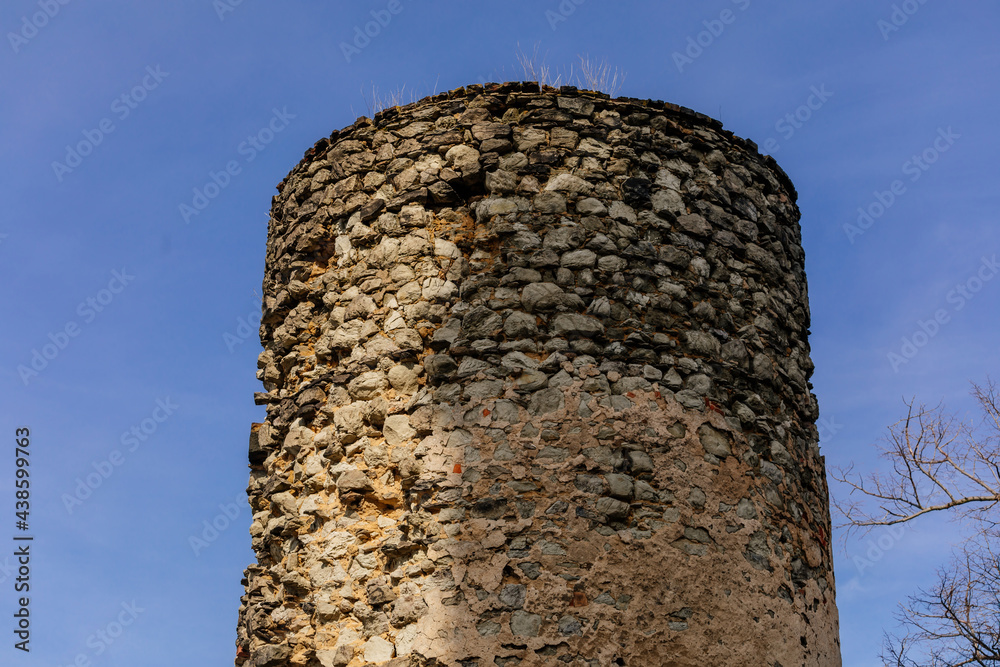 Medieval gothic castle Kostomlaty or Sukoslav , grey stone ruin on hill at sunny winter day, ancient fortress under snow, fairytale stronghold, round guard tower, Czech Republic