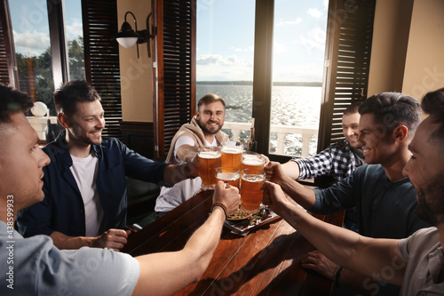 Photography Friends clinking glasses with beer in pub