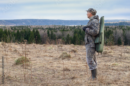 a shotgun case is slung over the shoulder of a hunter