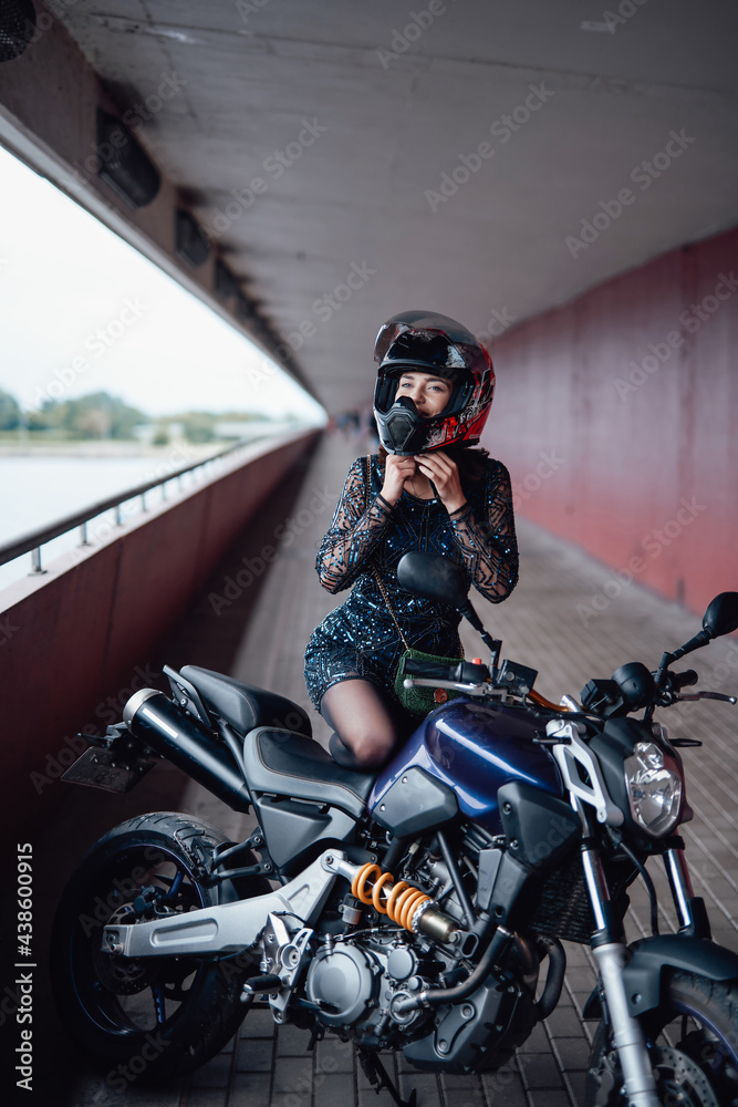 A beauty female driver with her bike on the bridge A beauty female driver with her bike on the bridge