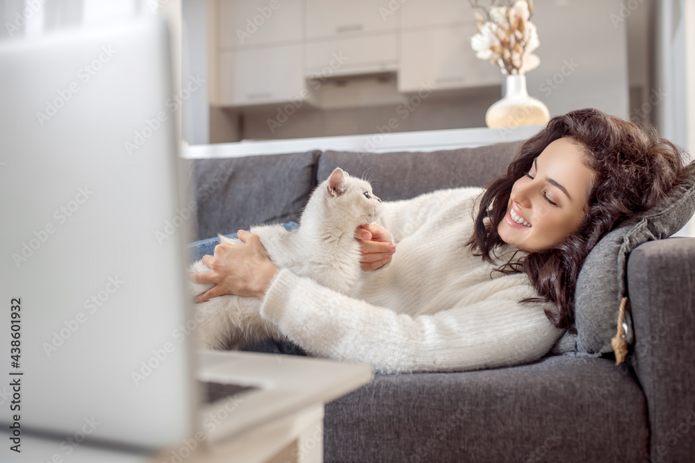 Young woman laying on the sofa with her cat and looking relaxed Young woman laying on the sofa with her cat and looking relaxed