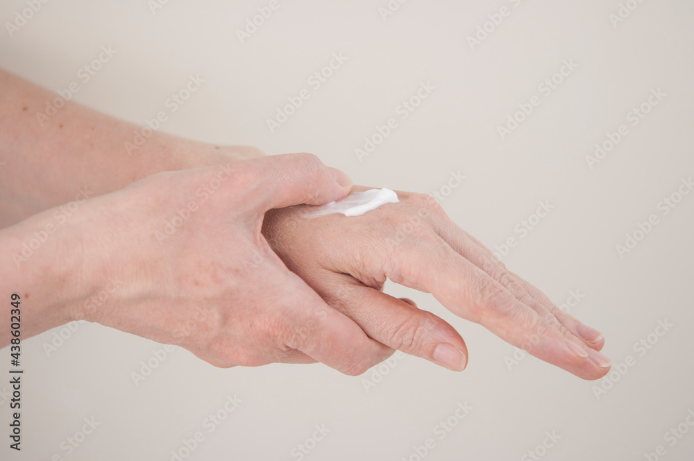 Close up of arm of young woman applying cream on her hand Close up of arm of young woman applying cream on her hand