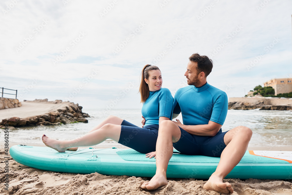Fototapeta premium Happy surfers with paddle board on the beach