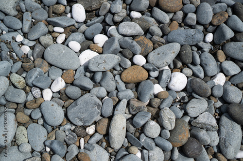 Gray stones on the beach. Beach pebbles. Beach stones background. Top view. Grey beach rocks background