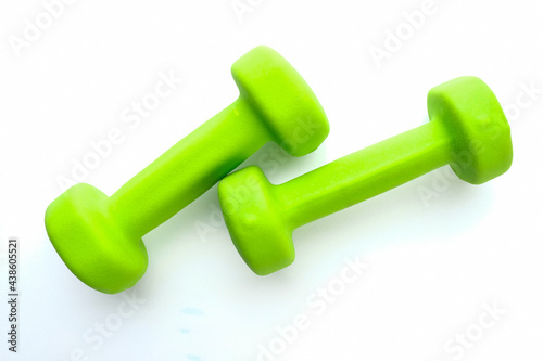 Green dumbbells on a white background. Sports and fitness.