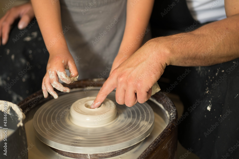 hands make a clay product out of clay on a circle