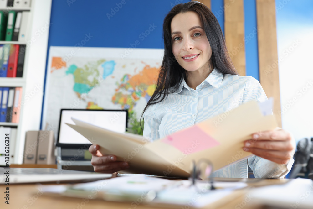 Fototapeta premium Portrait of business lady sitting at her desk and studying financial documents