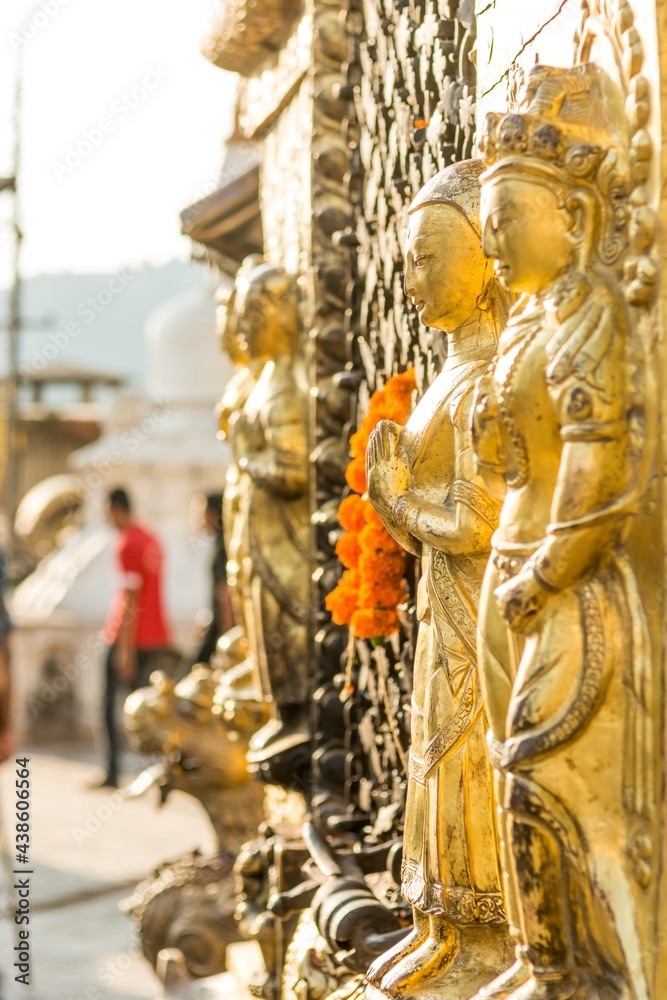 Fototapeta premium Closeup of religious statues glittering gold at sunset.