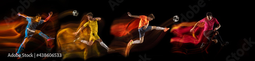 Sportsmen playing soccer football on black background in mixed light. Caucasian fit young male players in motion or action