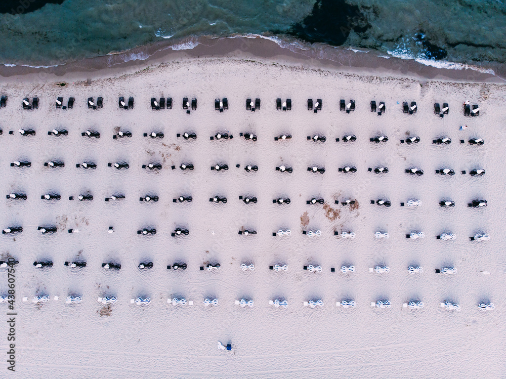 Summer background. Summer relaxation near sea. Sun umbrellas, sunbeds on sand beach, drone aerial view from above. Sunny Beach in Bulgaria. Summer holidays in Europe during quarantine.