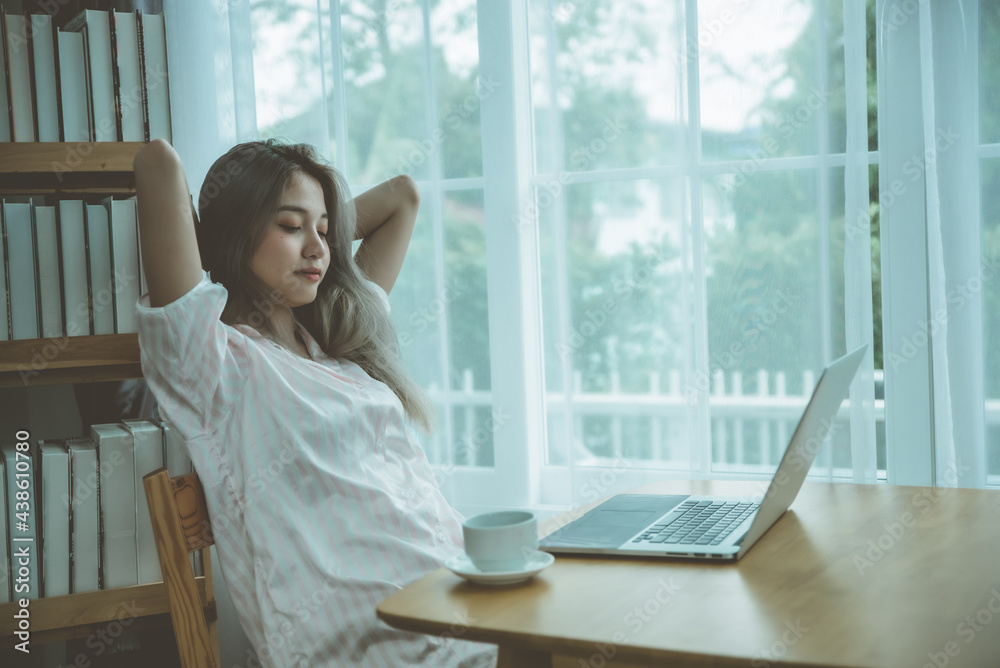 Lazy bored asian woman using laptop in the morning. Lazy bored asian woman using laptop in the morning.