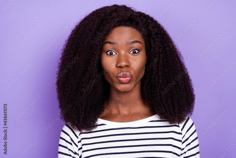 Photo of romantic young millennial lady blow kiss wear striped sweater isolated on violet color background Photo of romantic young millennial lady blow kiss wear striped sweater isolated on violet color background