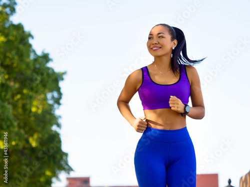 Fototapeta Naklejka Na Ścianę i Meble -  Asian woman running early in the morning. Attractive looking woman keeping fit and healthy.