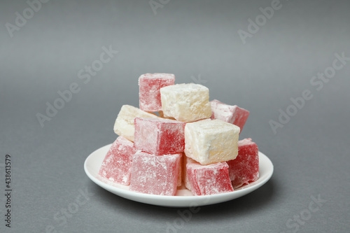 Plate with delicious turkish delight on gray background