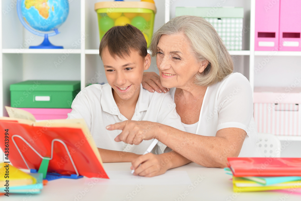 Fototapeta premium Granny with her grandson doing homework at home
