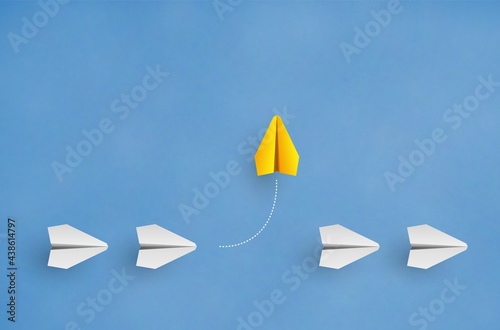 Individuality concept. Individual and unique leader yellow paper plane flies to the side photo