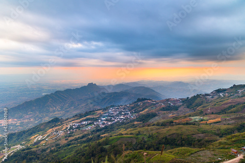Beautiful landscape of Phu tub berk. agriculture village on the mountain with layer mountain and cloudy with sunset background. © amornchaijj