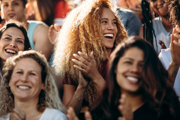 Woman watching a sport event and enjoying at stadium