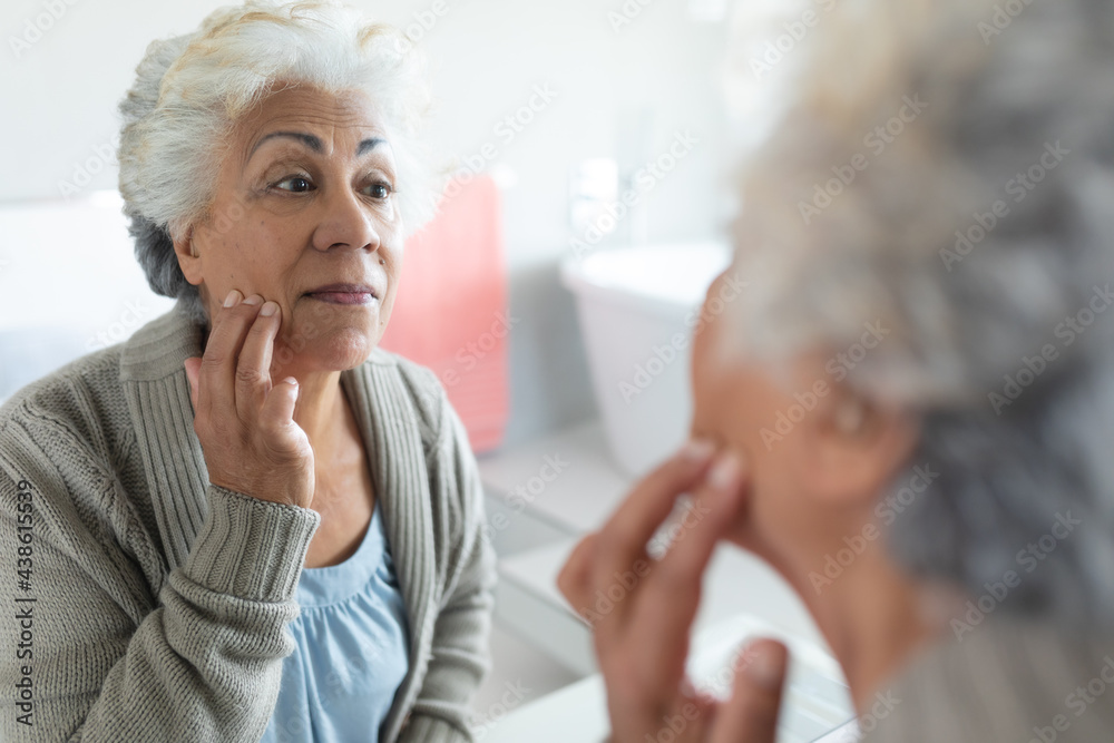 Mixed race senior woman looking at her reflection in mirror Mixed race senior woman looking at her reflection in mirror