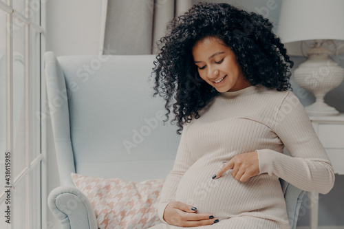 Fotografie Future african american mother in white dress talking with baby inside belly