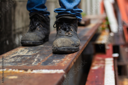 Wear safety shoes to ensure safety at work. construction workers wear safety shoes
