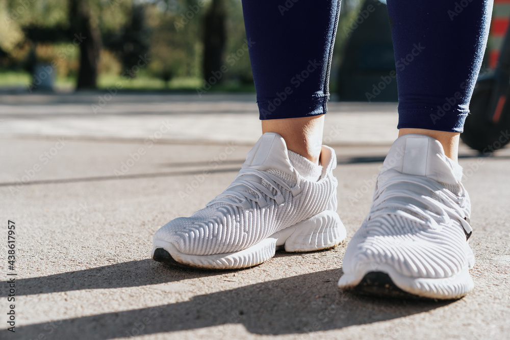 Feet of a woman dressed in sportswear and sneakers for running Feet of a woman dressed in sportswear and sneakers for running