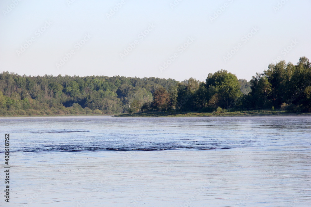A large river with white foam on the surface, during summer. River Daugava, Latvia