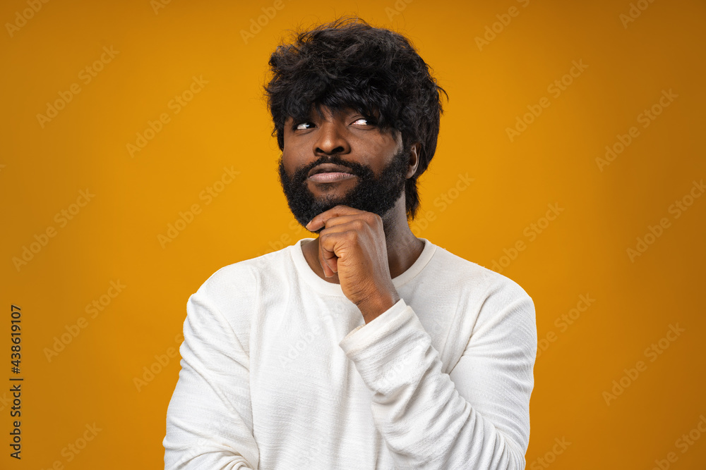 Young african american man thinking and touching his chin Young african american man thinking and touching his chin