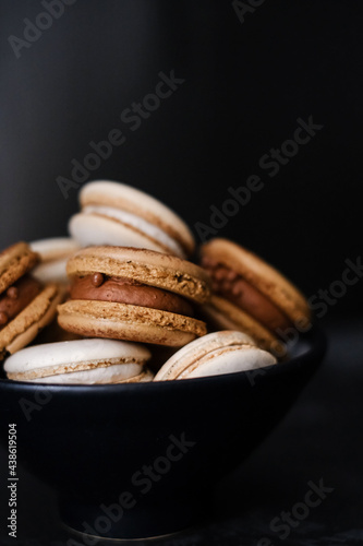 Macaroons on dark background, colorful french cookies macaroons. Macaroons. Vanilla and chocolate dessert. Healthy no sugar vegetarian. Gift for 8 March - International Women's Day
