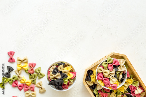Top view of coloured farfalle pasta in bowls