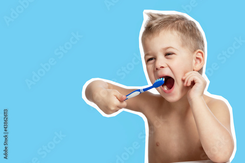 The little boy is actively brushing his teeth. Blue background. Close-up.