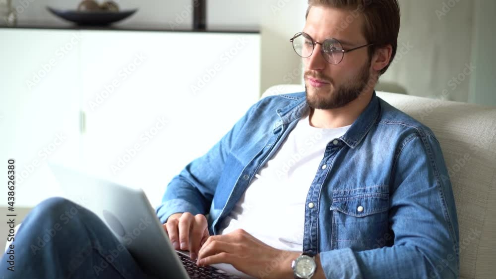 Young man sit in armchair use laptop, communicating remotely, working or studying distantly using modern wireless tech and internet connection Young man sit in armchair use laptop, communicating remotely, working or studying distantly using modern wireless tech and internet connection