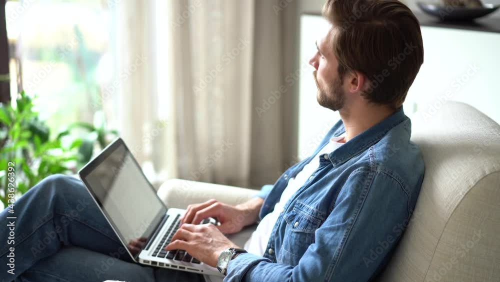 Young man sit in armchair use laptop, communicating remotely, working or studying distantly using modern wireless tech and internet connection Young man sit in armchair use laptop, communicating remotely, working or studying distantly using modern wireless tech and internet connection